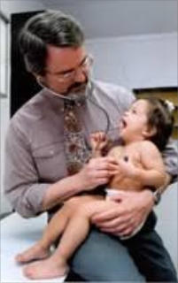 Fitzhugh Mullan holding a young child conducting a medical exam