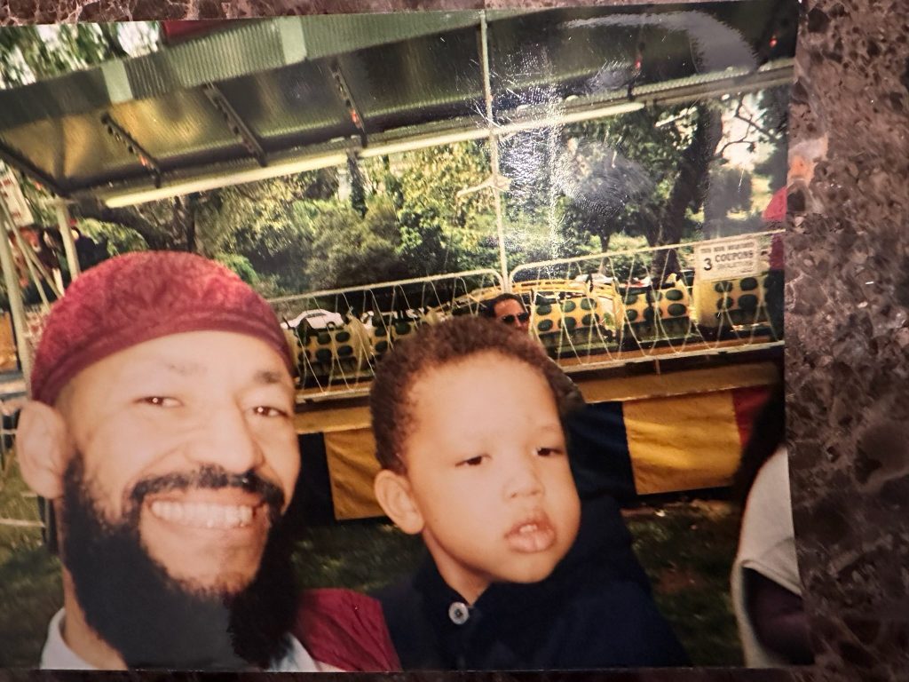 A very young Makeen and his Dad smiling for a photo