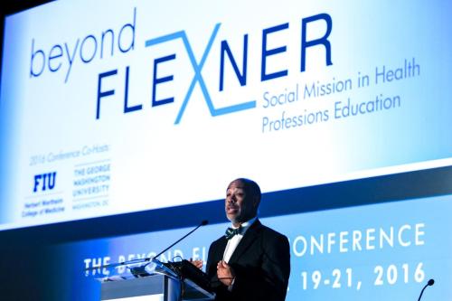 Person speaking at a podium at the Beyond Flexner conference.