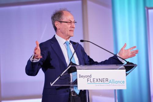 Sir Michael Marmot speaking at a podium at the Beyond Flexner conference