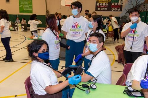 Healthcare professionals in an elementary school gym, treating walk-in patients