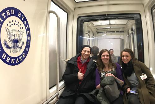 Students in the Capital subway system, with the US Senate seal on the train wall